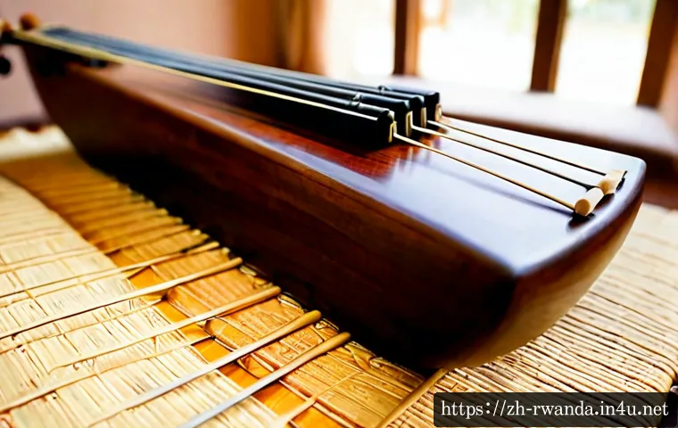 르완다의 주요 전통 악기 소개 - Photorealistic close-up of a handcrafted Rwandan inanga zither resting on a woven mat, polished wood...